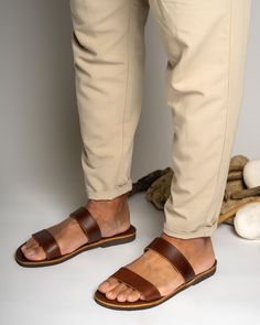 Men's handmade leather sandals in brown color are a stylish and functional choice for any occasion. Made from high-quality leather, these sandals are durable and comfortable to wear. The intricate detailing and design work add a touch of elegance to the overall look of the sandals.  All of our products are handmade with the best and highest quality leather from our beloved island of ''Crete''.  The leather used for each item may be irregular in terms of colour and texture due to its natural char Brown Leather Sole Slide Sandals, Brown Slide Sandals With Leather Sole, Casual Brown Toe Ring Sandals With Leather Sole, Brown Slides With Rubber Sole And Single Toe Strap, Brown Slides With Rubber Sole, Brown Slides With Single Toe Strap And Rubber Sole, Brown Leather Footbed Toe Ring Sandals, Brown Toe Loop Sandals With Leather Lining, Brown Slides With Leather Lining And Single Toe Strap