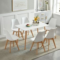 a white dining table and chairs in a room