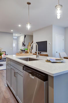 a clean kitchen with stainless steel appliances and white counter tops is pictured in this image