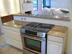 a stove top oven sitting inside of a kitchen next to a counter with white cabinets