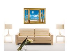 a living room with a couch, vase and large window overlooking the beach on a sunny day