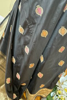 This exquisite handwoven banarasi silk saree in black with minakari anar buttis is nothing but enchanting. Beautiful border with tine beaded lines and traditional motifs accentuates the saree very well. The grand elaborate zari woven pallu is nothing but regal. Approximate Length 6.5 mtrs (inclusive of blouse length)Height - 46 - 52" Saree comes with fall, picot and tassels done. Blouse piece is cut. Approximate weight - 1.3 lbs Kindly Note : The colors you see on your device may vary due to the color reproduction, brightness and resolution of individual devices. If you'd like more clarity before your purchase, please contact our support team. Traditional Black Chanderi Saree, Black Art Silk Saree With Zari Work, Black Art Silk Saree With Pallu, Black Art Silk Saree With Traditional Drape, Black Chanderi Traditional Wear, Black Art Silk Saree For Diwali, Unstitched Black Art Silk Saree, Black Tussar Silk Dupatta With Traditional Drape, Black Tussar Silk Traditional Wear With Zari Work