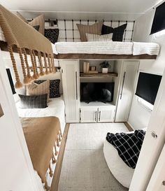 two beds in a small room with white walls and wood flooring on the bottom level