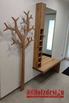 a wooden tree is next to a book shelf