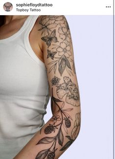 a woman's arm with flowers and butterflies tattooed on the side of her arm