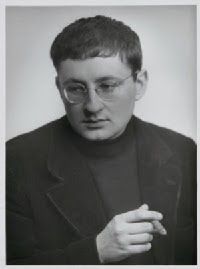 black and white photograph of a man with glasses holding his hand out to the side