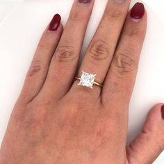 a woman's hand with a diamond ring on it