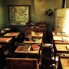 an empty classroom with desks and books on the desk in front of a map