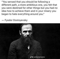 a man with a long beard wearing a suit and tie, in front of a quote from fyodor dostovevsky