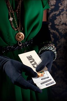 a person in black gloves holding a white card