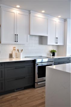 a kitchen with white cabinets and stainless steel appliances