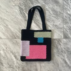 a crocheted bag sitting on top of a marble floor