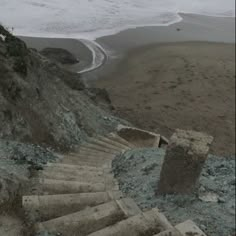 there is a set of stairs going up to the top of a hill next to the ocean