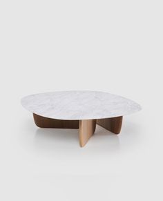 a white marble coffee table with wooden legs and an oval shaped design on the top