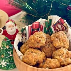 a wooden bowl filled with muffins on top of a table next to christmas decorations