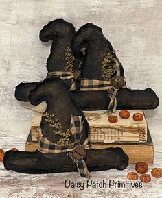 three black stuffed bears sitting on top of each other next to pumpkins and books