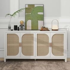 a white cabinet with wicker doors and a painting on the wall