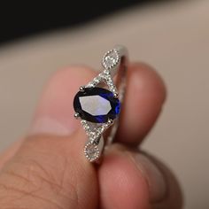 This is a gorgeous handmade creation. Its beauty is its simplicity & Elegance. The 6*8 mm oval shape faceted lab Sapphire is crafted in solid sterling silver and with rhodium plated. CZ as accents. All item is sent in a beautiful gift box If you have any idea of design your ring,pls contact me directly. You can realize more lovely stuff clicking the link https://www.etsy.com/shop/knightjewelry?refshopsection_shophome_leftnav Please leave the correct address and you phone number for deliverin Oval Diamond-cut Lab-created Sapphire Ring, Oval Cubic Zirconia Sapphire Ring Gift, Elegant Sapphire Birthstone Ring In Oval Shape, Oval Crystal Ring With Diamond Cut For Promise, Oval Diamond Cut Crystal Promise Ring, Elegant Oval Sapphire Ring In Sterling Silver, Elegant Oval Crystal Ring With Polished Finish, Silver Oval Sapphire Birthstone Ring, Oval Sapphire Birthstone Ring In Cubic Zirconia