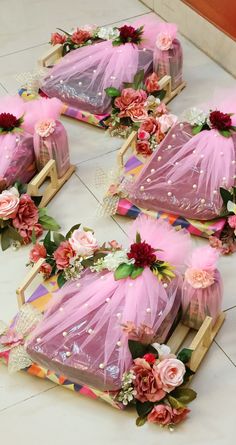 four pieces of pink tulle and flowers are on the floor next to each other