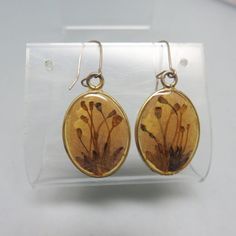 These very cool vintage sepia floral print  pierced earrings are sterling silver with a resin coating  .  They have the old fashioned ear wires and are in excellent condition.  They are not marked but the setting has been tested,  for sterling silver.  The wires are silverplated.  They measure 1 3/4ths inches tall and 5/8ths inch wide. These will arrive in a lovely gift box.  If you like vintage accessories, vintage costume jewelry, old bolo ties and silver jewelry,  please see my Etsy store for more selections, www.etsy.com/shop/PANDPF Unique Pressed Flowers Earrings, Vintage Brown Drop Earrings, Handmade Vintage Round Flower Earrings, Unique Drop Earrings With Natural Inclusions, Vintage Nickel-free Drop Flower Earrings, Vintage Dangle Flower Earrings, Vintage Dangle Flower Earrings With Ear Wire, Vintage Oval Earrings For Gift, Vintage Gold Teardrop Flower Earrings