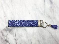 a keychain with a blue and white design on it sitting on a marble surface