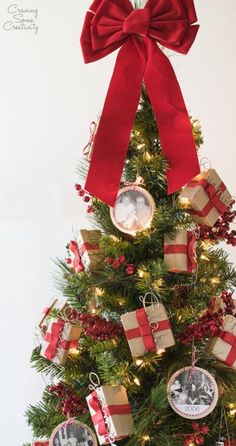 a christmas tree decorated with red and gold ribbon, ornaments and pictures hanging from the top