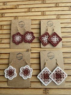 crocheted earrings and earring set displayed on wooden table with brown card board