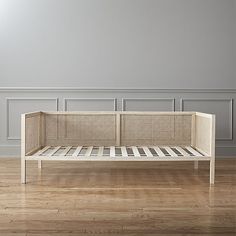 a white bed sitting on top of a hard wood floor