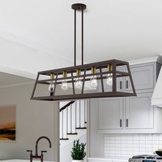 a kitchen with white cabinets and an island in front of a stove top oven under a chandelier