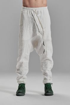 "DISTORTED BOILED LINEN DROPPED CROTCH TROUSERS WITH ELASTIC WAISTBAND__ These contemporary boiled linen trousers are created to escape the mainstream similarly. A distorted front is offset by two irregular pockets on the back, asymmetrically positioned on different levels, and J shaped, arched legs, cause the pants to stay very bunched up, embodying the most brutally urban and masculine silhouette__ who__ Conceptual Thinker when__ Cool Evenings where__ From The Studio To An Underground Party mo Fitted White Bottoms With Pockets, White Full Length Pants With Belt Loops, White Full-length Bottoms With Belt Loops, White Linen Full-length Bottoms, Baggy White Parachute Pants With Pockets, White Baggy Parachute Pants With Pockets, White Baggy Full-length Parachute Pants, Baggy White Harem Pants, White Straight Pants With Belt Loops