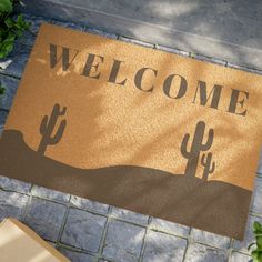 a welcome mat is shown on the ground next to a potted plant and box