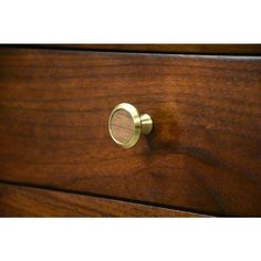 a close up of a wooden drawer with a metal knob on the top and bottom