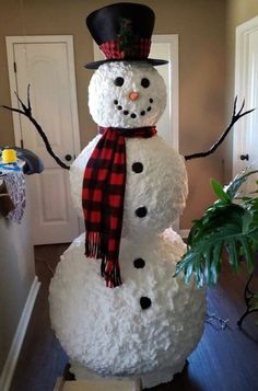 a snowman made out of fake foam with a top hat and scarf