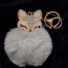 a keychain with a fox head on it and some beads hanging from it