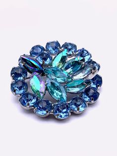 Dating from the late 1950s, here is the brooch from the paradisiacal color that features good quality stones assembled with a lot of imagination,  for so creates a nice movement in the center The rhinestones on the edge are 8mm round, with a nice baby blue color, they frame a handful of Navettes with AB luster, arranged obliquely, they create a really nice three-dimensionality! among the Aurora Borealis navettes there is one that has peacock luster  ...I don't know if a repair / replacement has Vintage Blue Brooches For Jewelry Making, Retro Wedding Brooches With Rhinestones, Blue Costume Jewelry Brooch For Wedding, Blue Vintage Brooch For Party, Costume Jewelry Blue Brooches With Rhinestones, Vintage Blue Brooches With Rhinestones, Blue Crystal Brooches With Rhinestones, Unique Blue Brooch For Party, Unique Blue Brooches For Party