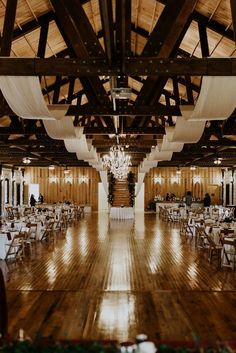 an empty ballroom with wooden floors and chandeliers