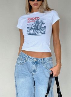 Looking for the perfect fitting Western Rodeo Cowboy Baby Tee to wear to your next country concert or 4th of july? Our comfortable and trendy baby tees are perfect for yourself or as a gift!   SIZING -This is a "youth" Gildan 5000B t shirt -Please review the size chart to ensure you order the correct size -Model is wearing (in order) a size S in white, M in sports grey, XS in white -These shirts reflect the vintage 90's baby tee fit and hit at hip length. They may fit looser around the waist and Graphic Crop Top Outfit, Vintage Tv Ads, Cowboy Vibes, Country Concert Shirts, Cowboy Graphic, Cowgirl Baby, Western Baby, Cowboy Baby, Rodeo Shirts