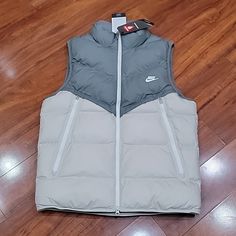 Nwt Men's Size M Nike Storm-Fit Vest. Style Is Standard Fit. Color Is Grey With Off-White. Approx Pit To Pit : 22" Approx Width Across Hem : 20.75 " Approx Length From Top Of Front Shoulder (Next To Collar) To Hem : 27 " Note: There Is Teeny Tiny Catch Below Back Collar And Inside Collar From Where They Removed The Sensor. It Is Not Noticeable, See Last 2 Pics. White Vest For Streetwear In Fall, White Fall Streetwear Vest, Nike White Outerwear For Cold Weather, White Winter Streetwear Vest, White Outdoor Vest For Fall, White Winter Vest For Cold Weather, Nike Vest, Vest Style, Running Vest