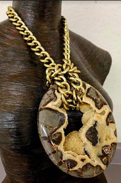 Septarian is among some of the oldest gemstone on earth. It consists of a combination of calcite, aragonite and limestone. They were formed approximately 50-70 million years ago in Utah, and metaphysically, it is considered to be a grounding stone. (I leave this to the individual buyer to determine). This heavily crystallized oval pendant measures 5.5" x 5" and the stone can be reversed by removing the chain. It closes with an xl fancy lobster claw clasp. The chain, fully extended, measures 34". When attached it will measure about 15" per side. This piece is heavy and it is unisex, but men will probably find it more comfortable to wear given it's weight. From the Atelier of Kat Kouture. (If you shorten the chain your sternum will support the weight and not your neck). Antique Brown Agate Jewelry, Luxury Brown Jewelry With Natural Stones, Antique Agate Healing Jewelry, Brown Gemstone Round Pendant Jewelry, Artisan Gold Gemstones With Natural Stones, Gold Round Gemstones With Large Stone, Bronze Gemstone Round Pendant Jewelry, Bronze Round Pendant Jewelry With Gemstone, Bronze Jewelry With Natural Stones In Round Pendant