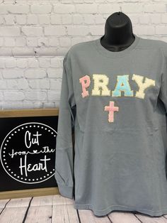 Welcome To Cut From The Heart!  This listing is for (1) chenille patch Pray t-shirt, long sleeve OR sweatshirt.  *Shirt Color Is Gray*  Please see the drop-down menu for options. This design is offered in standard (Tultex or Gildan) or premium brand (Comfort Colors).  *Note that the Comfort Colors size chart is the same as the Gildan/Tultex as they are owned by the same manufacturer*  *Please note that due to out-of-stock issues the t-shirt brand shown in the listing photo may be swapped to a similar brand.  * Design is a actual chenille patch.  * Sizes Available Are Listing In The Drop Down Menu.  * All items are made to order, therefore we do not accept refunds or exchanges. * Processing times are 7-10 business days + shipping. * We offer group discounts and wholesale pricing - just ask! Long Sleeve Cotton T-shirt With Embroidered Graphics, Cotton Long Sleeve T-shirt With Embroidered Graphics, Cotton Long Sleeve Tops With Letter Patch, Gray Long Sleeve Pre-shrunk T-shirt, Gray Tops With Embroidered Graphics For Streetwear, Gray Embroidered Streetwear Tops, Gray Embroidered Tops For Streetwear, Gray Screen Print Tops For College, Long Sleeve Gray T-shirt With Text Print