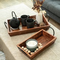 two wooden trays with candles and coffee cups on them sitting on top of a table