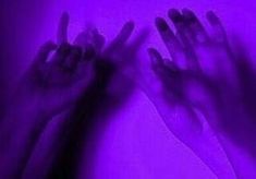 two hands reaching up in front of a purple background