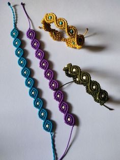 three crocheted bracelets sitting next to each other on top of a table