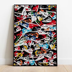 an abstract painting with colorful sneakers on it's black frame against a white wall