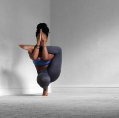 a woman is doing yoga on the floor with her hands up in front of her face