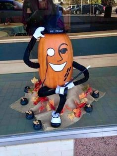 a large pumpkin with a hat on it's head sitting in front of a store window