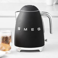 the smeg kettle is next to a glass of tea