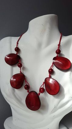 Tagua nuts make this African beaded necklace a versatile piece that works with most outfits. length: 8.5 inches when worn. *Ready to ship *Handmade *Eco friendly Please note that this is a handmade product, and the color pattern of the tagua nuts will differ for each necklace Your finished necklace is similar, but not exactly identical. Also, the color of the photo images may differ slightly due to variations in computer resolution. Images may also appear larger. Tagua nuts, also known as vegeta Red Bohemian Shell Necklace For Gift, Fair Trade Unique Beaded Necklaces, Adjustable Shell Necklace With Wooden Beads As Gift, Adjustable Round Beads Shell Necklace, Unique Wooden Beaded Necklaces, Handmade Bohemian Drop Necklace With Round Beads, Gift Wooden Beaded Necklaces, Gift Wooden Beads Necklace, Handmade Red Shell Necklace Gift