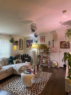 a living room filled with lots of furniture and decor on top of a hard wood floor