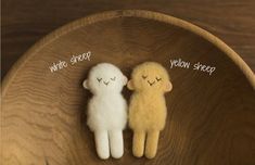 two small stuffed animals sitting on top of a wooden bowl with words written below them